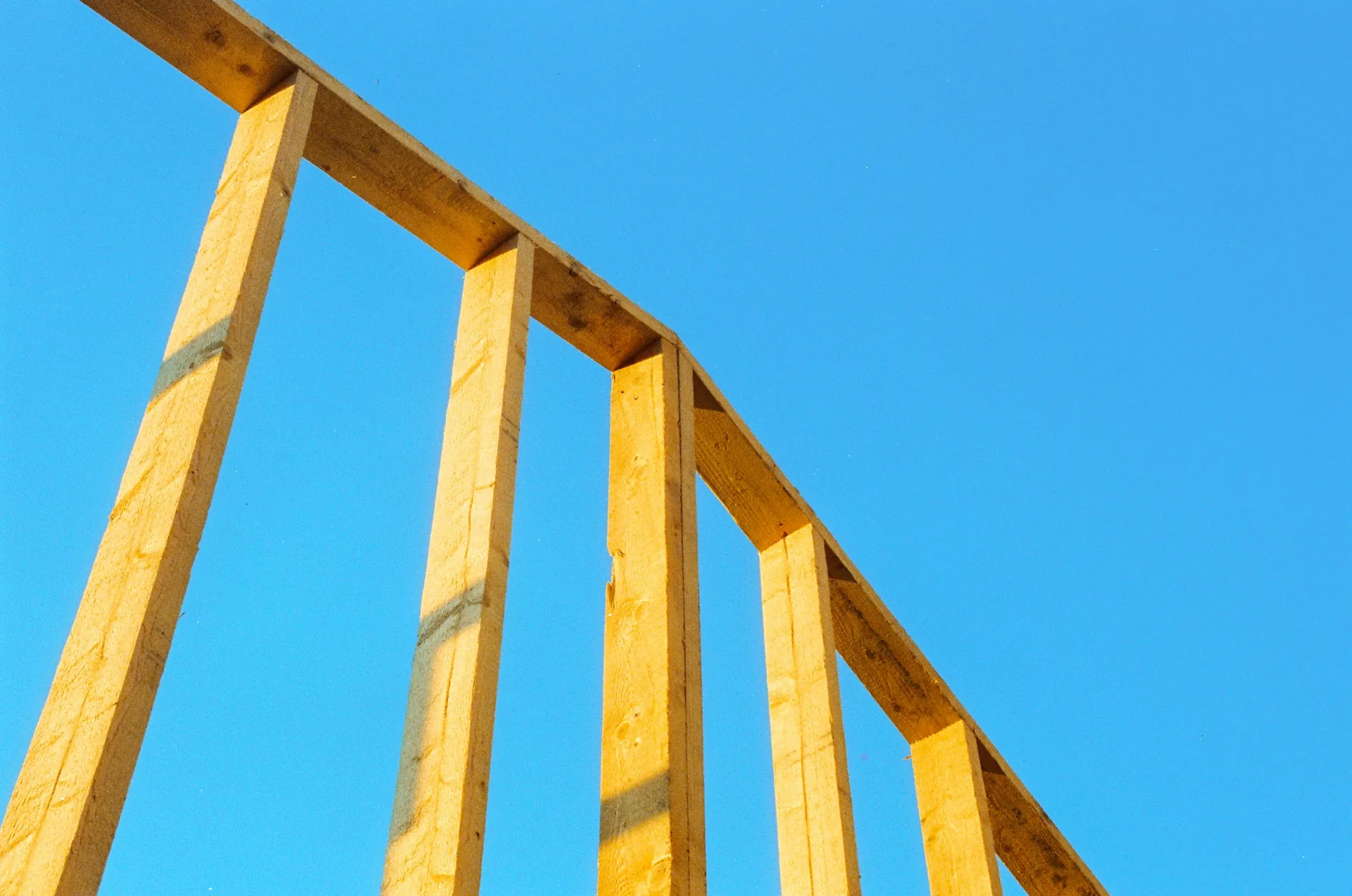 Wood framing members against a blue sky